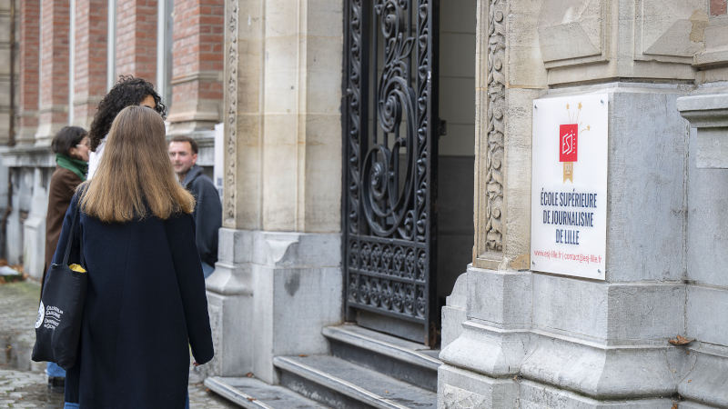 Deux jeunes femmes devant la porte métallique de l’ESJ